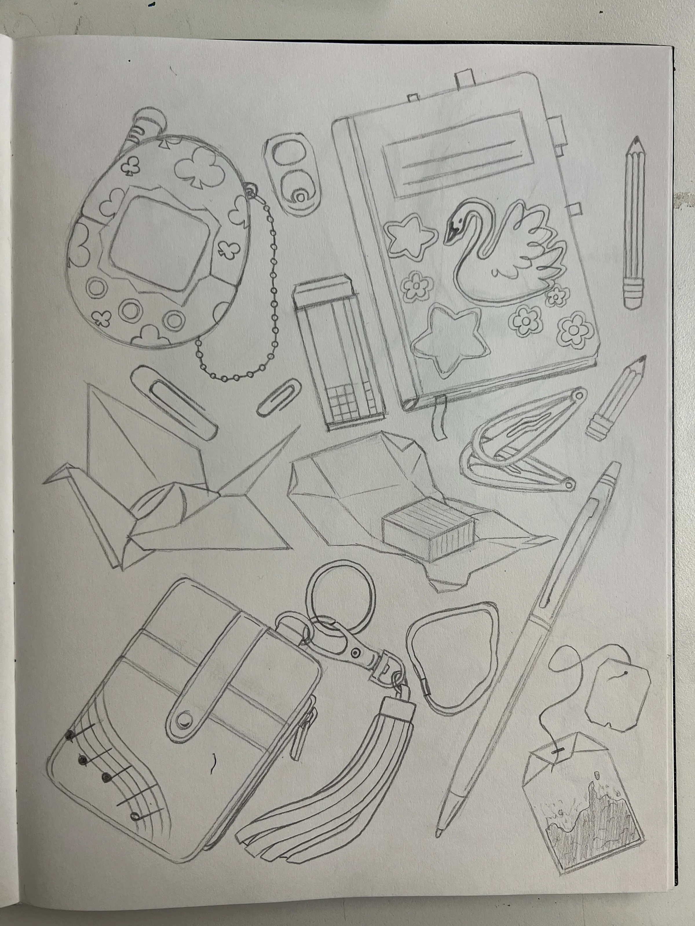 Item page — A pencil page of everyday objects — a handheld console, an origami crane, pens, a pouch, keyrings and tea bags.